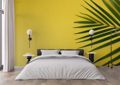 Palm leaf on yellow background. Minimal tropical plants composition with vivid yellow color background. Wall mural