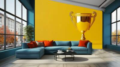 gold winner cup on yellow background. A shiny golden trophy stands alone against a vibrant yellow backdrop, symbolizing achievement and success in competitions. Wall mural