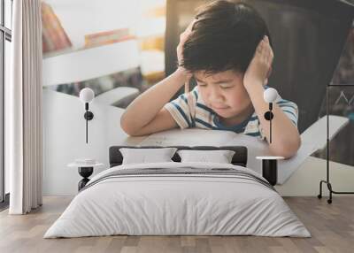 Asian child working on hard homework Wall mural