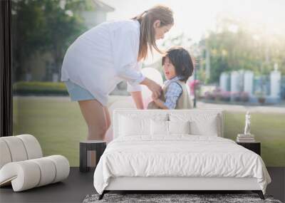 Asian mother and son holding hand together and walking Wall mural