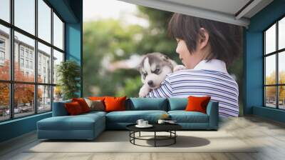 Cute asian child holding siberian husky Wall mural