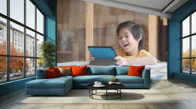 Cute Asian child learning class study online with video call from tablet at home .Social distancing  concept Wall mural