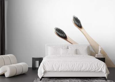 Close-up picture of two wooden toothbrushes, on white back. Wall mural