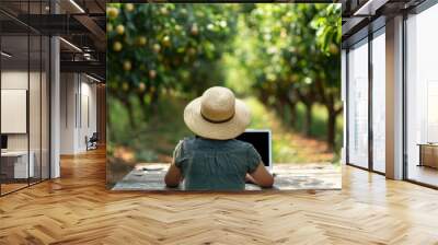 Rural Bliss Remote Worker in Straw Hat Embracing Nature at Wooden Table in Orchard Stock Image Wall mural