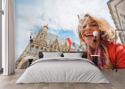 Woman stands on the background of St. Stephen's Cathedral in Vienna with the flag of Austria in hand, Austria Wall mural