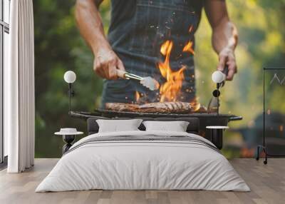 A man is cooking meat and vegetables on a BBQ grill. Wall mural