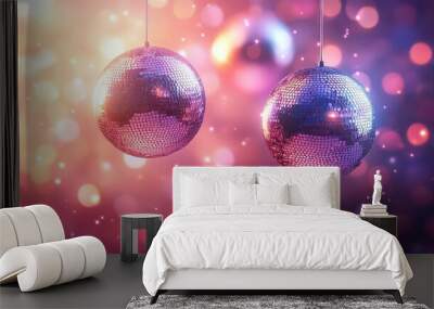  Two shiny Christmas ornaments hanging with glowing lights in the background, evoking holiday joy and celebration. Wall mural