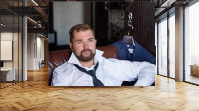 A business man is putting on his suit coat. Wall mural