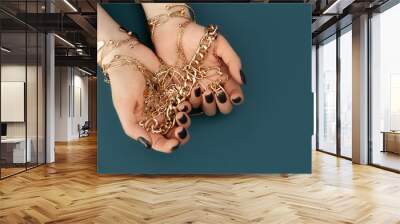 Female hands with trendy dark nail design with gold bracelets on aqua background. Luxury concept. Festive backdrop for your design. Top view. Wall mural