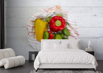 Peppers of different colors on a rustic cloth and wooden backgro Wall mural