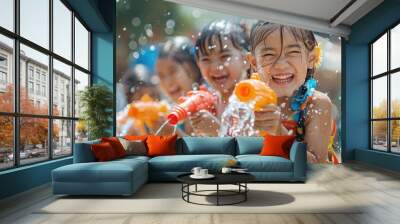 Laughing children engaged in playful water gun fun under the bright summer sun, splashes glistening in the air, Songkran. Wall mural