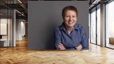 Happy smiling middle-aged woman in blue shirt Wall mural