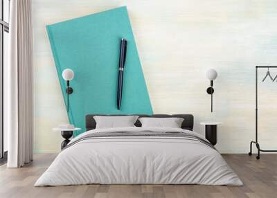 A photo of a teal blue journal with a pen, an elegant diary, notebook or planner, shot from above with copy space Wall mural