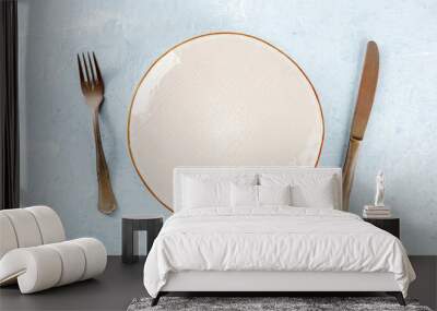 An empty white plate with a gold rim, with a fork and a knife, overhead flat lay shot on a slate background, the concept of dinner Wall mural