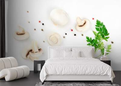 Champignon mushrooms, whole and sliced, shot from the top on a white background with pepper and parsley leaves, a flat lay composition with a place for text Wall mural