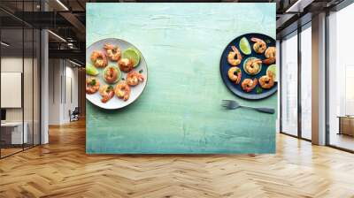 Shrimps, overhead flat lay shot with copy space. Cooked shrimp with lime, two plates, shot from the top on a teal blue background Wall mural