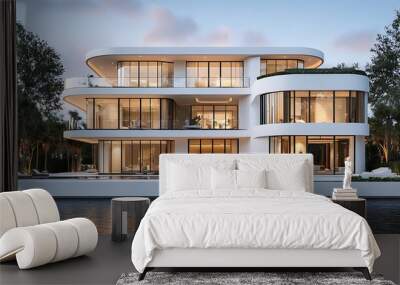 A modern, white, luxury house with large windows, a balcony, and a swimming pool is situated on the waterfront with a view of a river at sunset. Wall mural