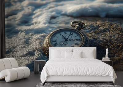 An antique pocket watch lays on the beach with white sand and a wave of sea foam around it. Wall mural