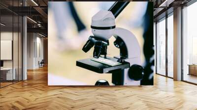 Modern white microscope on blurred background. Concept of teaching biochemistry to students and schoolchildren. Selective focus Wall mural