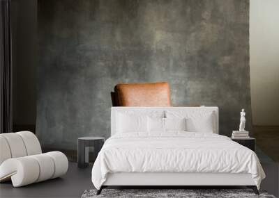 Empty brown leather chair against concrete wall Wall mural