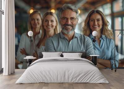 A charismatic senior man with gray hair among a group of young professionals, all smiling and looking confident Wall mural