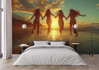 A group of women race towards the setting sun, their silhouettes against the colorful sky as they run along the water's edge on a beach Wall mural