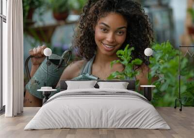 A joyous young woman waters plants in a greenhouse with a metal watering can, her connection to nature evident Wall mural