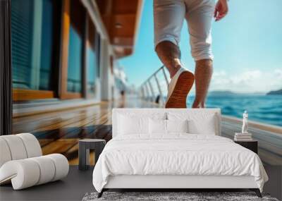 A person dressed in casual white attire strolls confidently along the luxurious wooden deck of a yacht, with sun glistening on the surrounding sea and clear skies. Wall mural