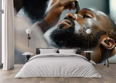 Close-up of barber trimming beard of Black man Wall mural