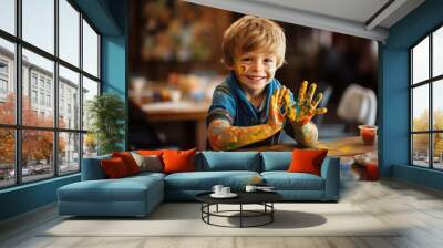 Portrait of a cheerful boy with hands and face stained with paint Wall mural