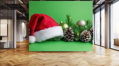 Santa hat with pine branches and baubles on green Wall mural