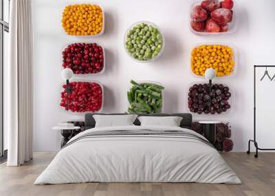 Frozen berries and vegetables in plastic boxes isolated on white background. Wall mural