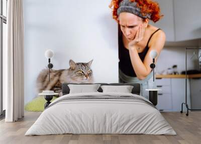 portrait gray fluffy cat sitting on cat tree and teenage girl, cat's owner Wall mural