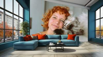 portrait red-haired teenage girl with gray fluffy cat Wall mural