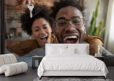 Joyful Black couple taking a selfie while holding house keys, celebrating their new home purchase with excitement and pride Wall mural