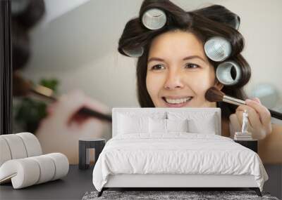 woman in curlers applying makeup Wall mural