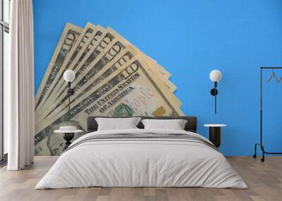 Bundle of ten dollar bills banknotes on blue background Wall mural