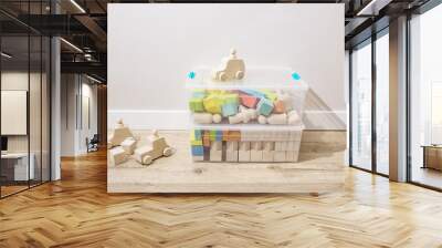 Wooden cubes, kids toys sorted in plastic containers, stand on the floor in the nursery room. Concept of making toys from ecological materials, sorting and organizing things, storage, home Wall mural