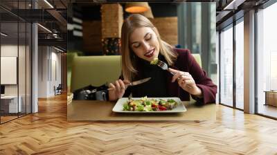 Blonde woman eating green healthy tasty eco salad on city cafe Wall mural