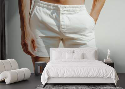 man is wearing white shorts and holding his hands in his pockets. The image has a casual and relaxed mood Wall mural