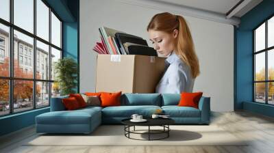 woman is holding a cardboard box with a plant inside Wall mural