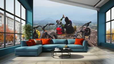  Asian lover woman and man Travel Nature. Travel relax ride a bike Wilderness in the wild. Sit on a rocky cliff. Wall mural