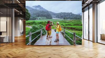 Lover asian man asian women travel nature. Walking a photo the rice field and stop take a break relax on the bridge at  ban mae klang luang in rainy season. Wall mural