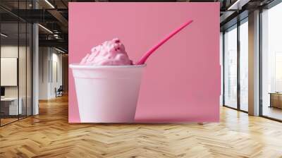 Strawberry yogurt or pudding in a white plastic cup set against a pink background, with room for text. The yogurt is a pretty pink color and there is a spoon inside. Simplistic design. Wall mural