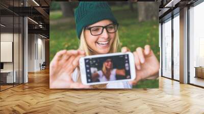 Blonde woman posing outdoor, taking self portrait Wall mural