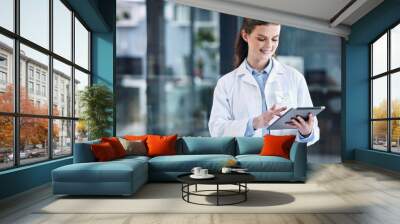 Telehealth, tablet or happy doctor in hospital with research on online media to search for medicine info. Woman, smile or medical healthcare professional browsing on technology for news in clinic Wall mural