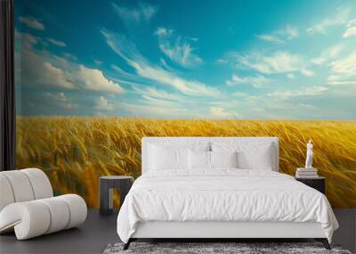 Golden Wheat Field Under a Vast Blue Sky: Golden wheat field swaying gently in the wind, bathed in warm sunlight beneath a vast blue sky adorned with fluffy white clouds, evoking a sense of tranquilit Wall mural