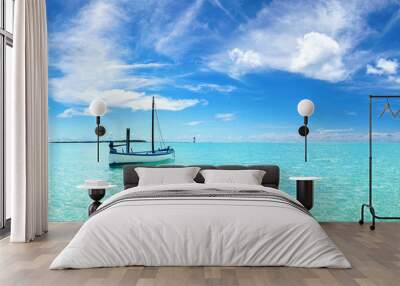 Boat in turquoise ocean water against blue sky with white clouds and tropical island. Natural landscape for summer vacation, panoramic view. Wall mural