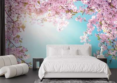 Branches of blossoming pink sakura macro with soft focus on gentle light blue sky background in sunlight with copy space. Beautiful floral image of spring nature. Wall mural