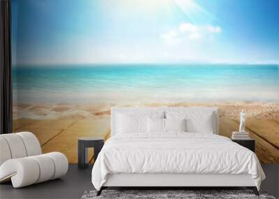 tropical summer beach with empty wooden flooring in rays of sun light on nature. Golden sand beach, ocean against blue sky with white clouds. Copy space, summer vacation concept. Wall mural